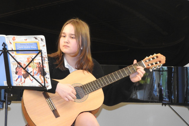 Dziewczynka gra na gitarze klasycznej
