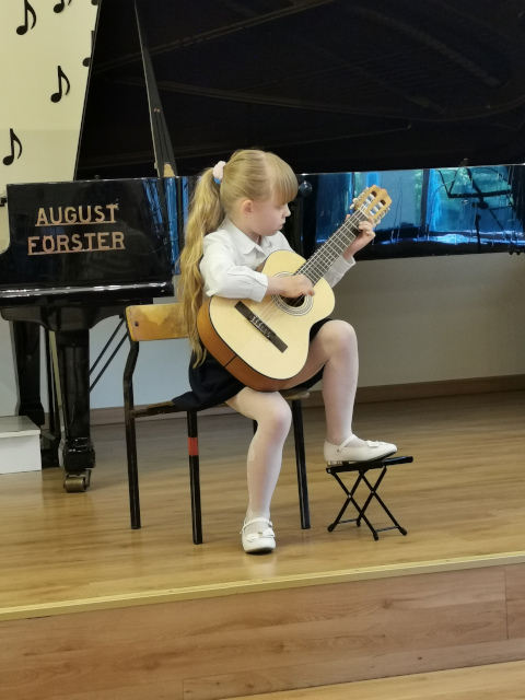 dziewczynka gra na gitarze klasycznej